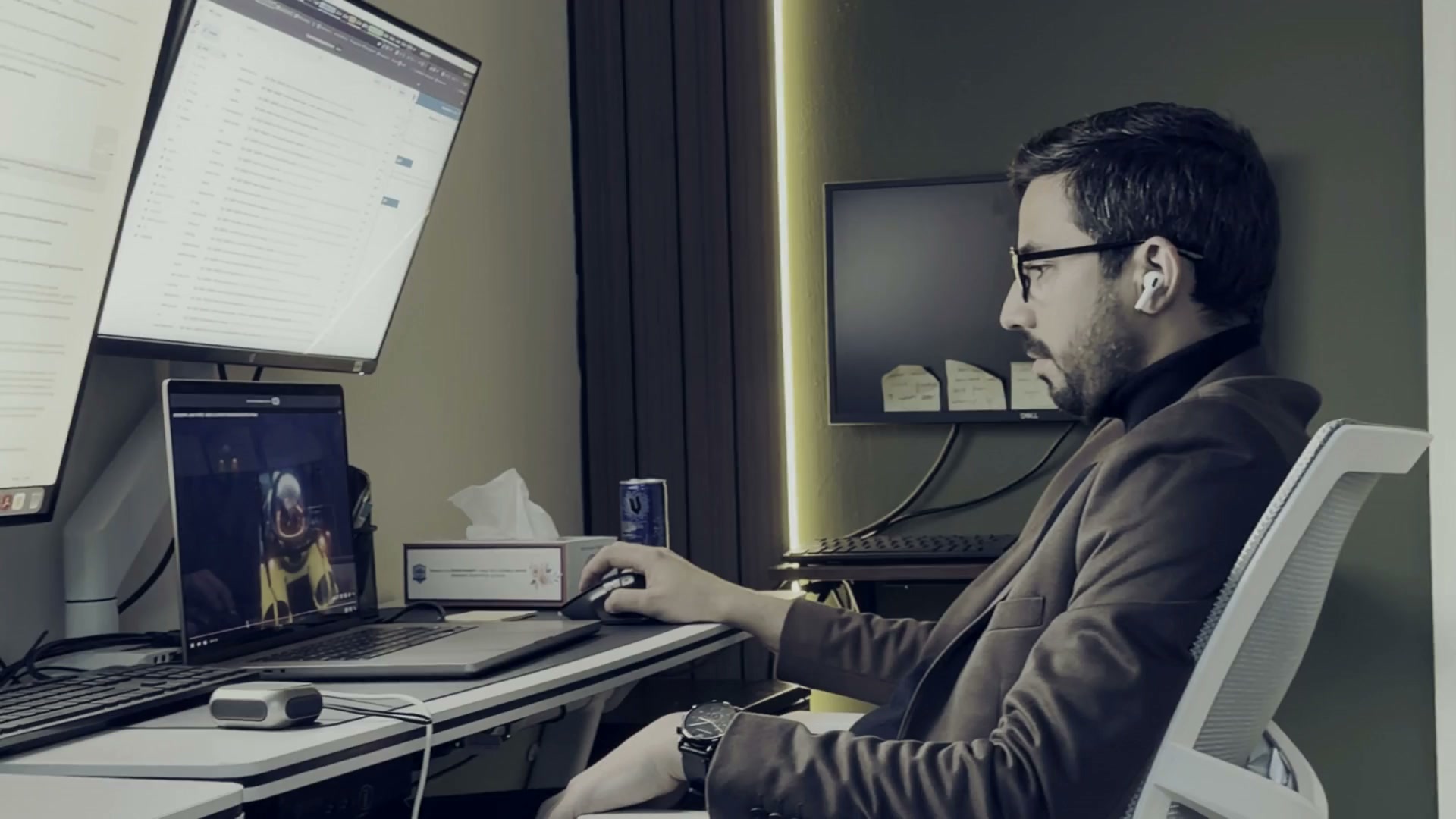 Bisar working at his desk at night, lit by monitors and an amber LED strip.